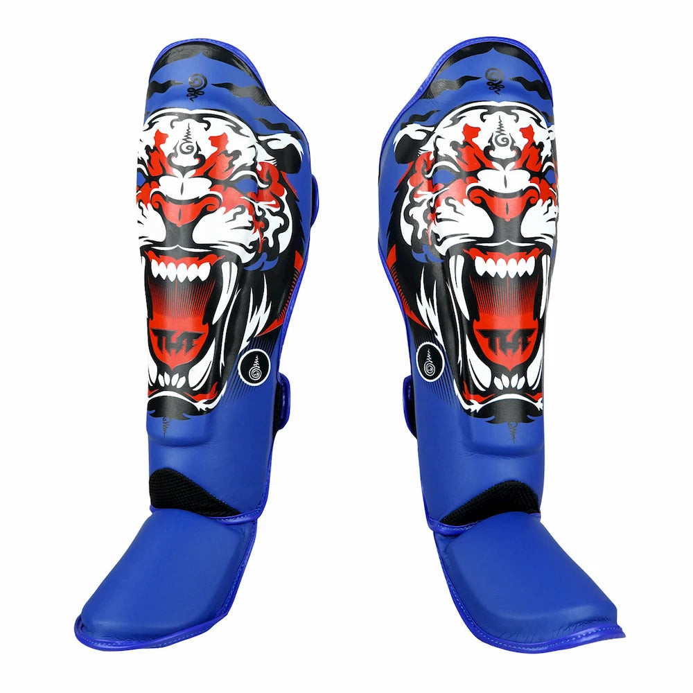 Blue shin guards with a tiger design on a white background