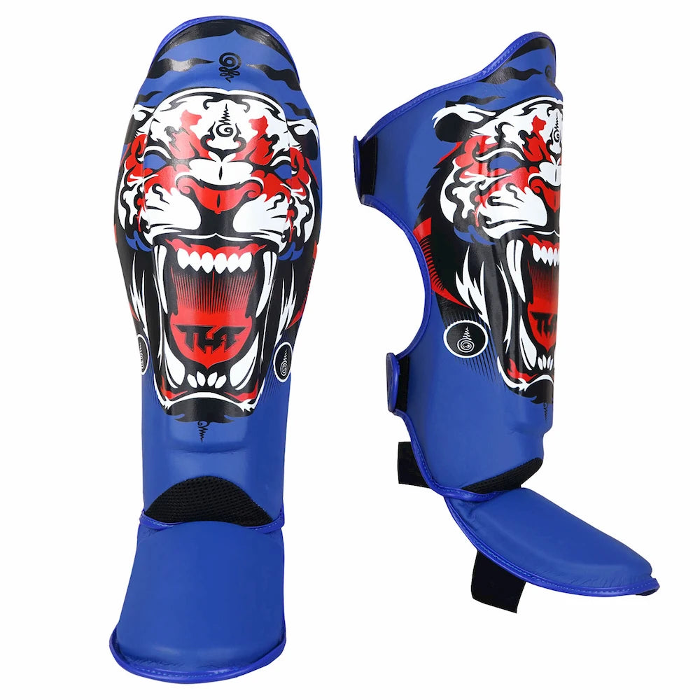 Blue shin guards with a tiger design on a white background