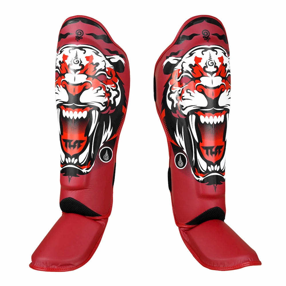 Red Thai shin guards with a tiger design on a white background