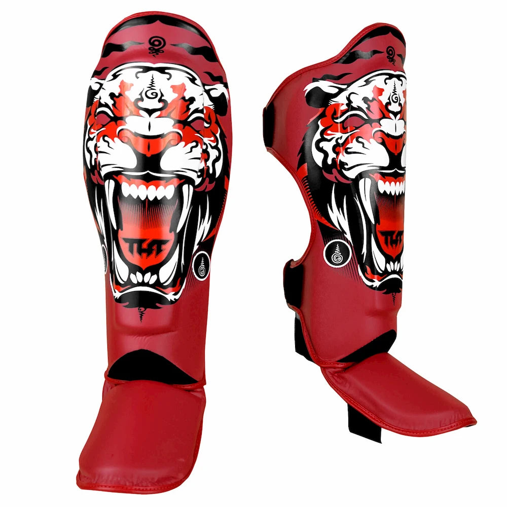 Red Muay Thai shin guards with a tiger design on a white background