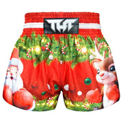 Red Muay Thai boxing shorts with Christmas-themed design featuring Santa Claus and reindeer on a white background.