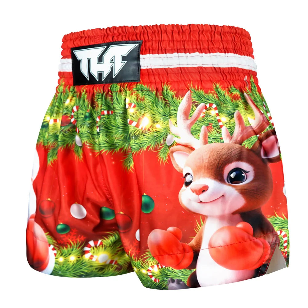 Red Muay Thai boxing shorts with Christmas-themed design featuring a reindeer and festive elements on a white background.