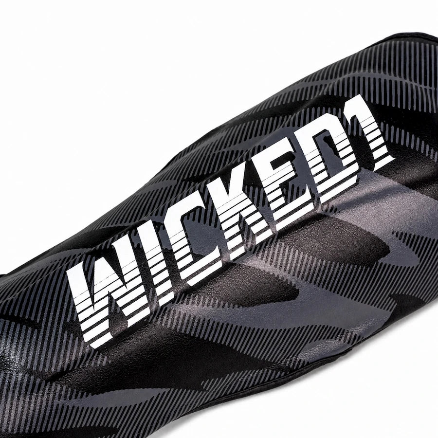 Close-up of a black athletic sleeve or leg guard with a gray tonal pattern and a large white 'WICKED1' logo across the front.