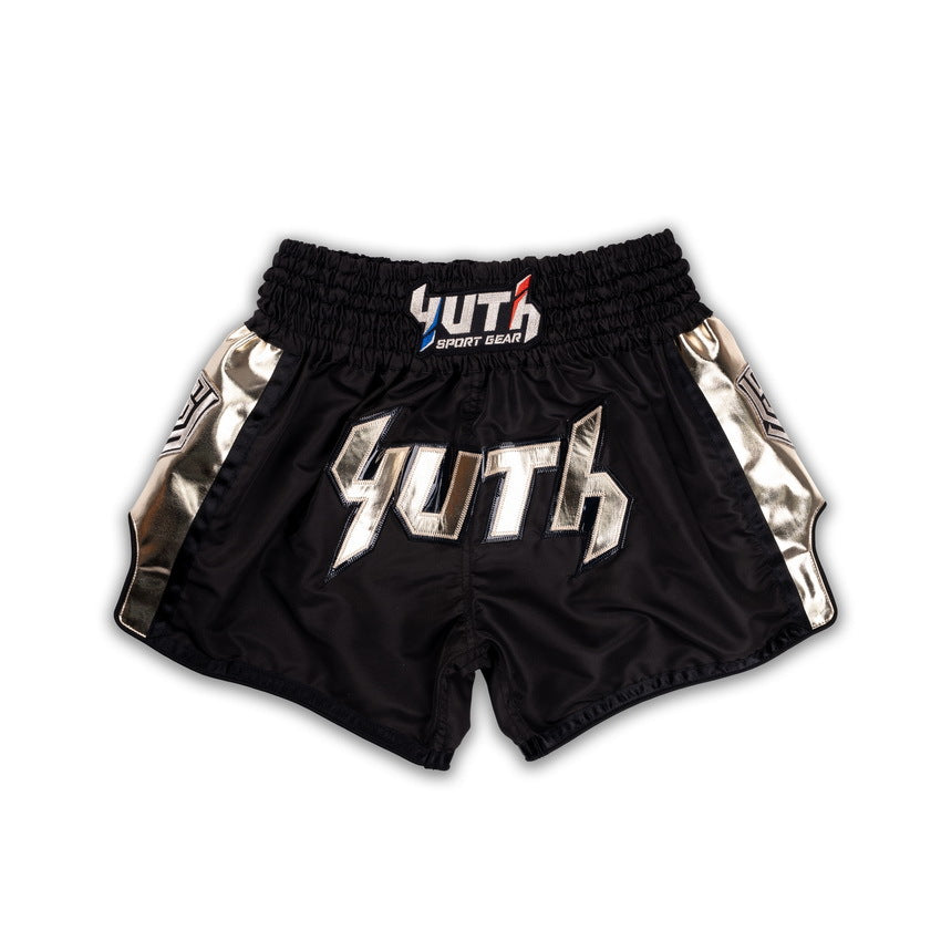 Black Muay Thai shorts with metallic accents and 'Yuth' branding on a white background