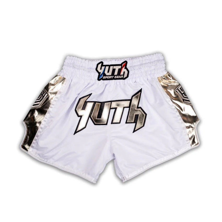White Muay Thai shorts with gold accents and a logo on a white background