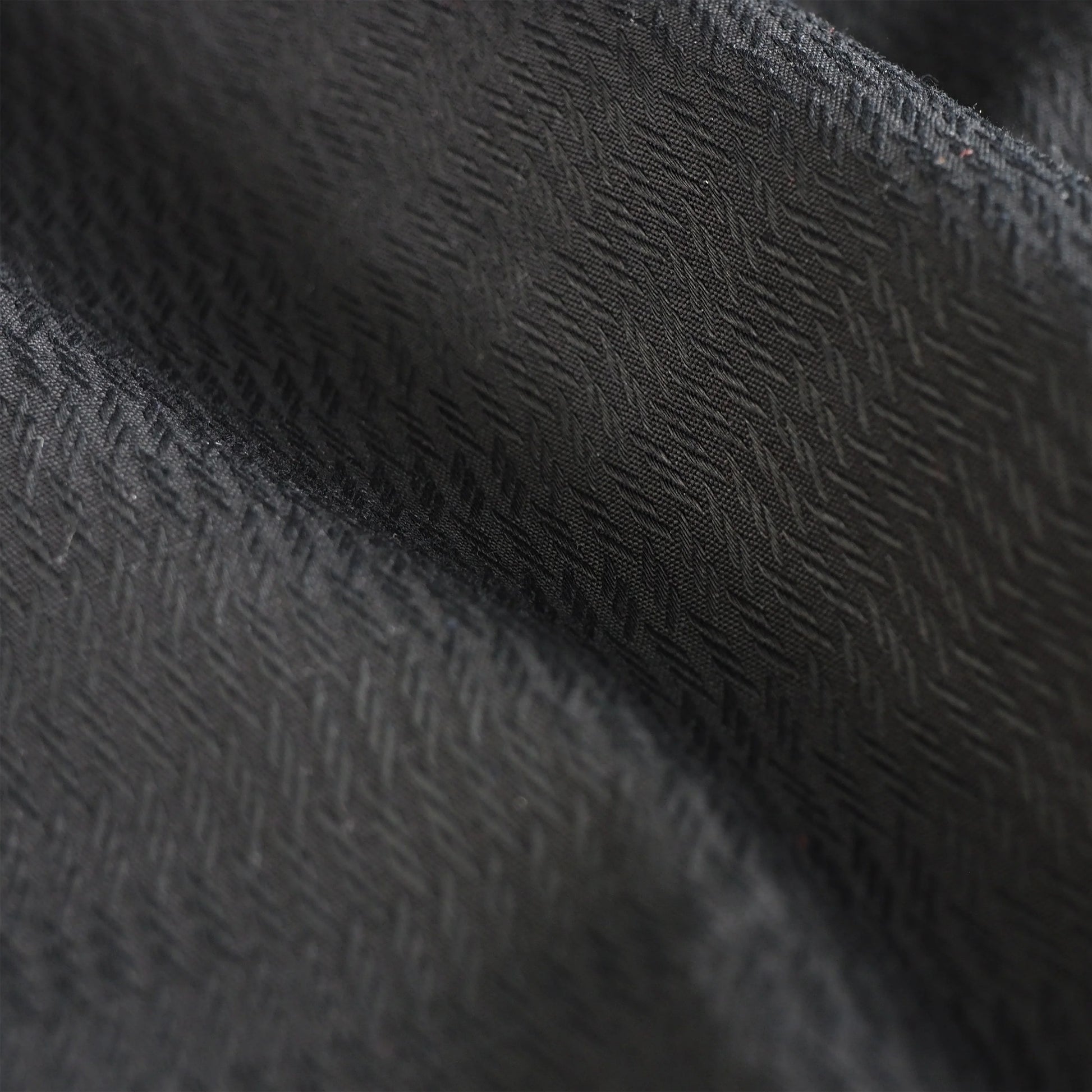Close-up of textured black fabric with a subtle pattern