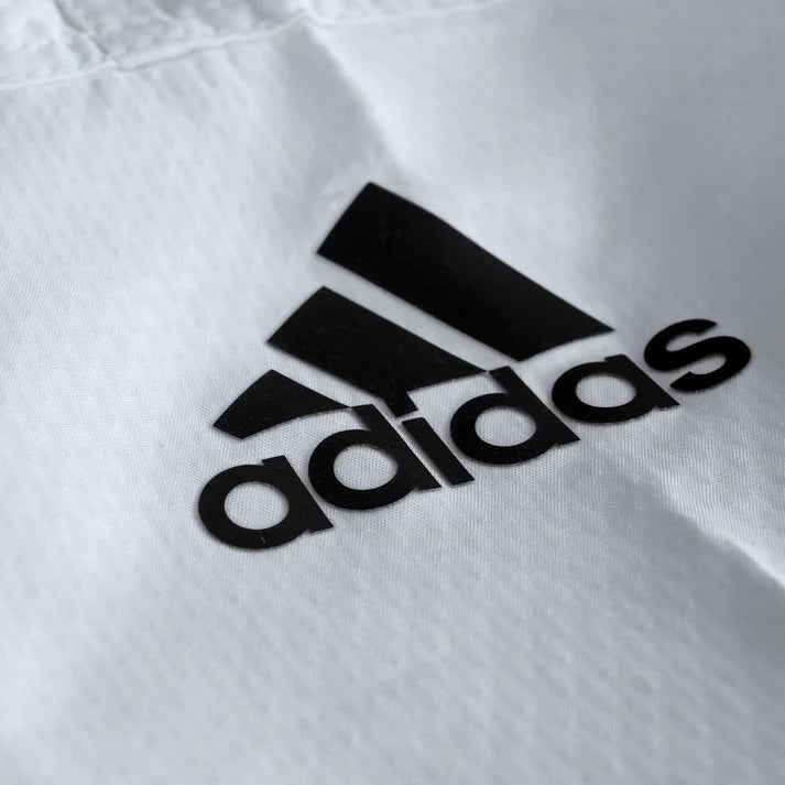 Black Adidas logo on a white fabric background