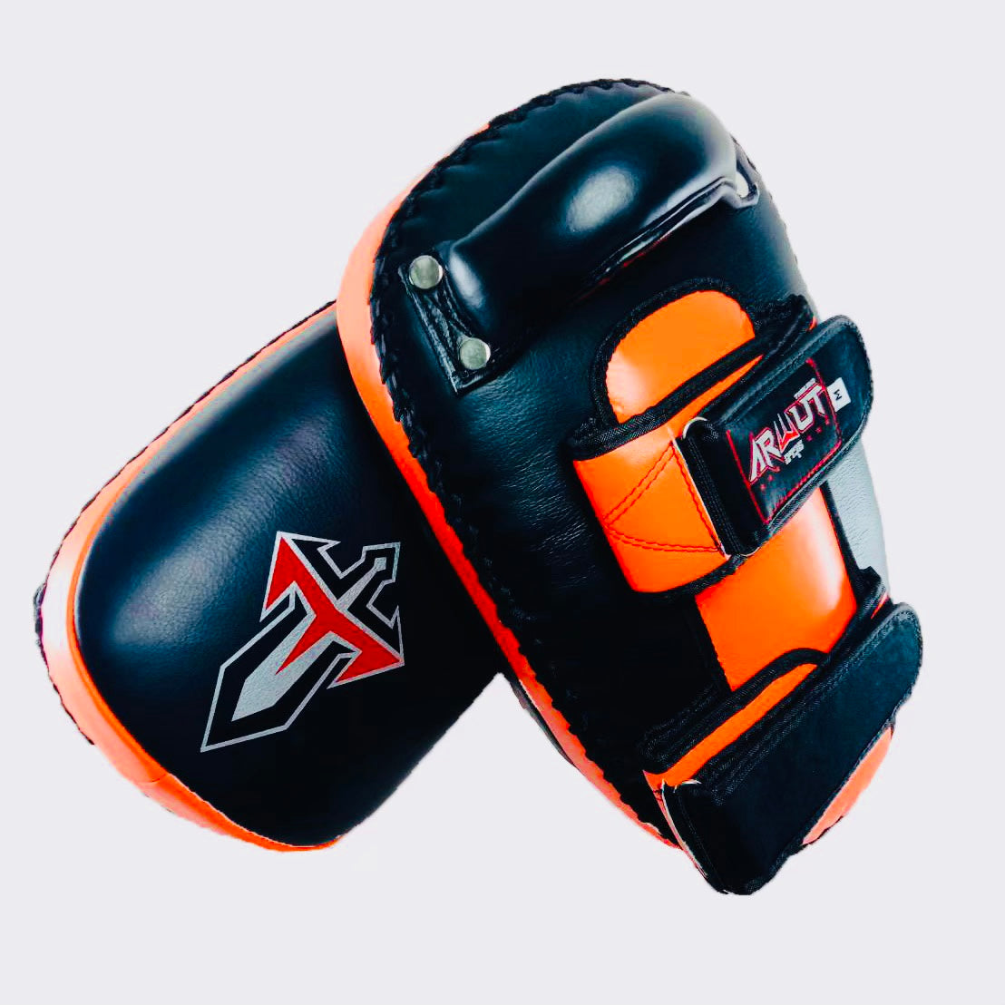 Pair of black and orange Muay Thai pads on a light gray background