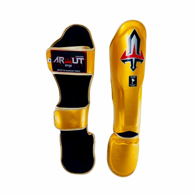 Pair of gold and black Arwut shin guards with a brand logo on a white background