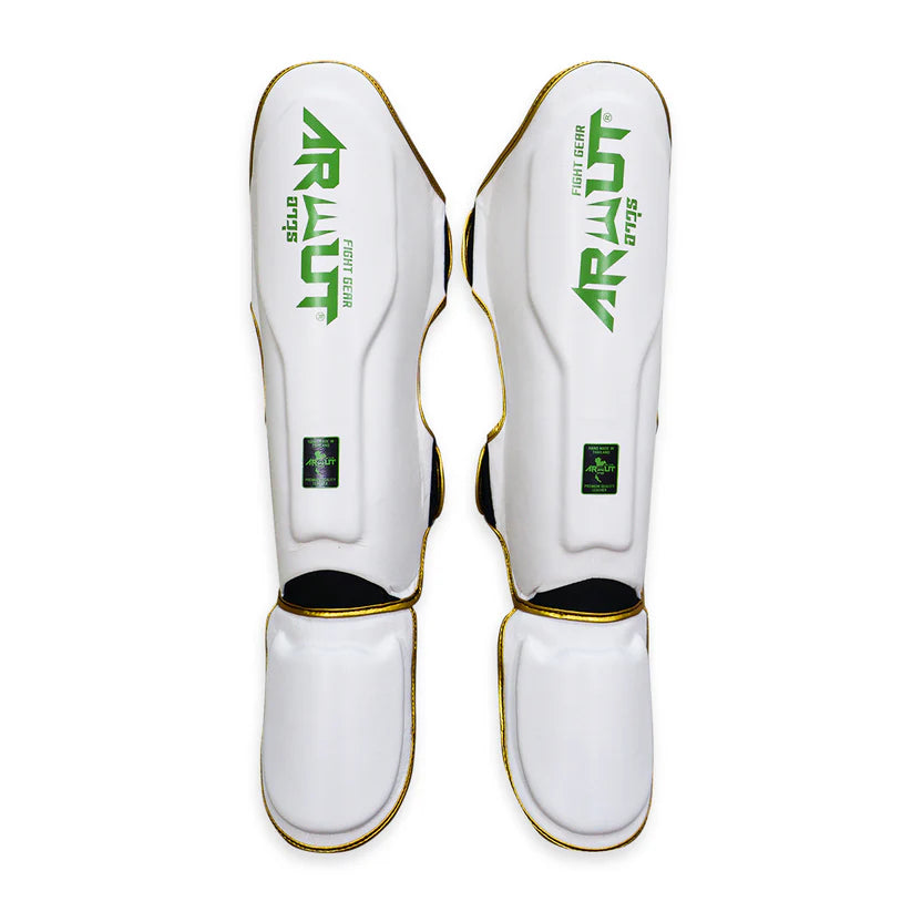 White shin guards with green and black branding on a white background