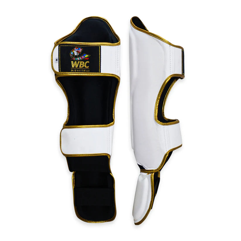White shin guards with gold accents featuring WBC logo on a white background
