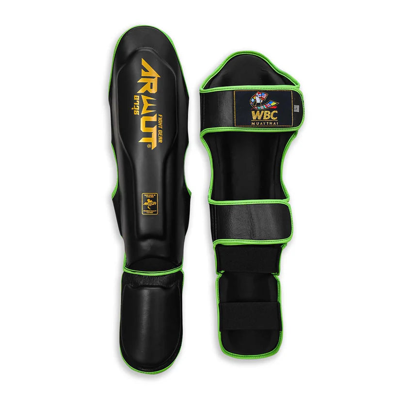 Black shin guards with green accents featuring WBC and Arwut branding on a white background.