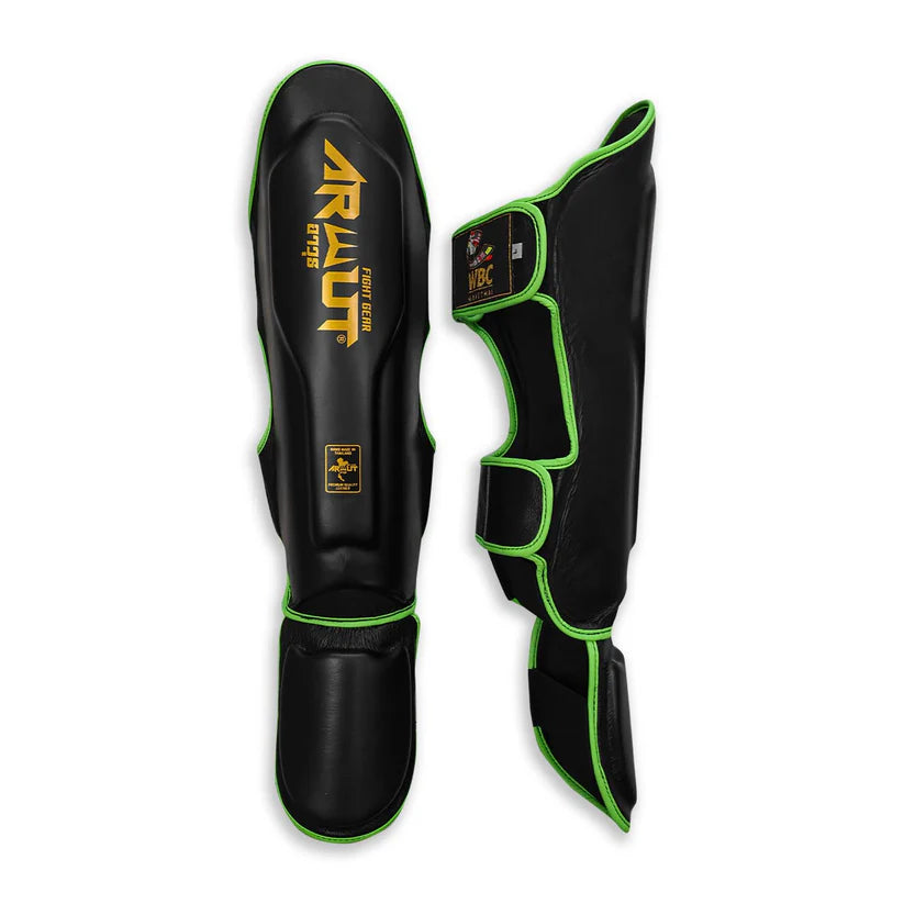 Black shin guards with green accents and 'Arwut' branding on a white background