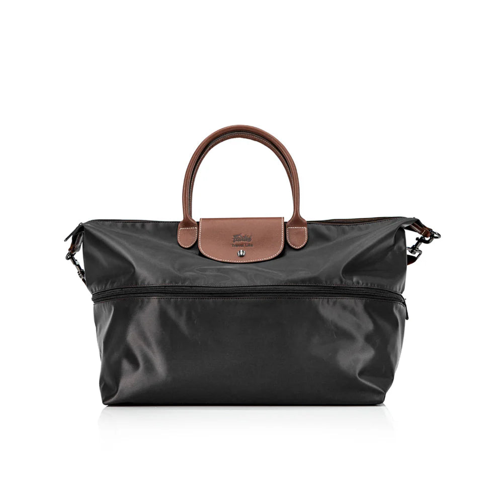 Black travel bag with brown leather handle and flap on a white background