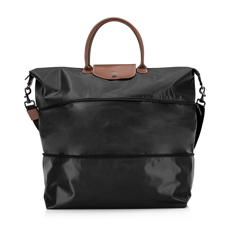 Black travel bag with brown leather handle and shoulder strap on a white background