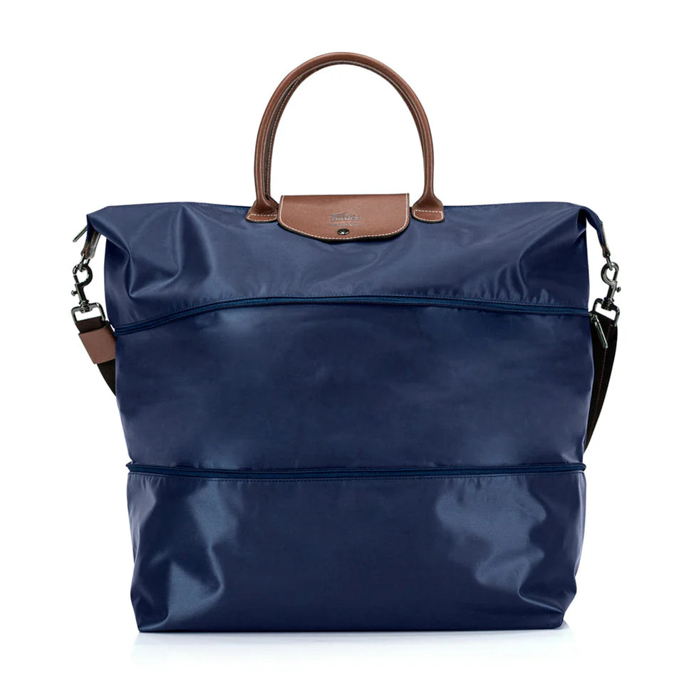 Blue bag with brown handle and strap on a white background