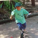 Child running outdoors with a frisbee in hand