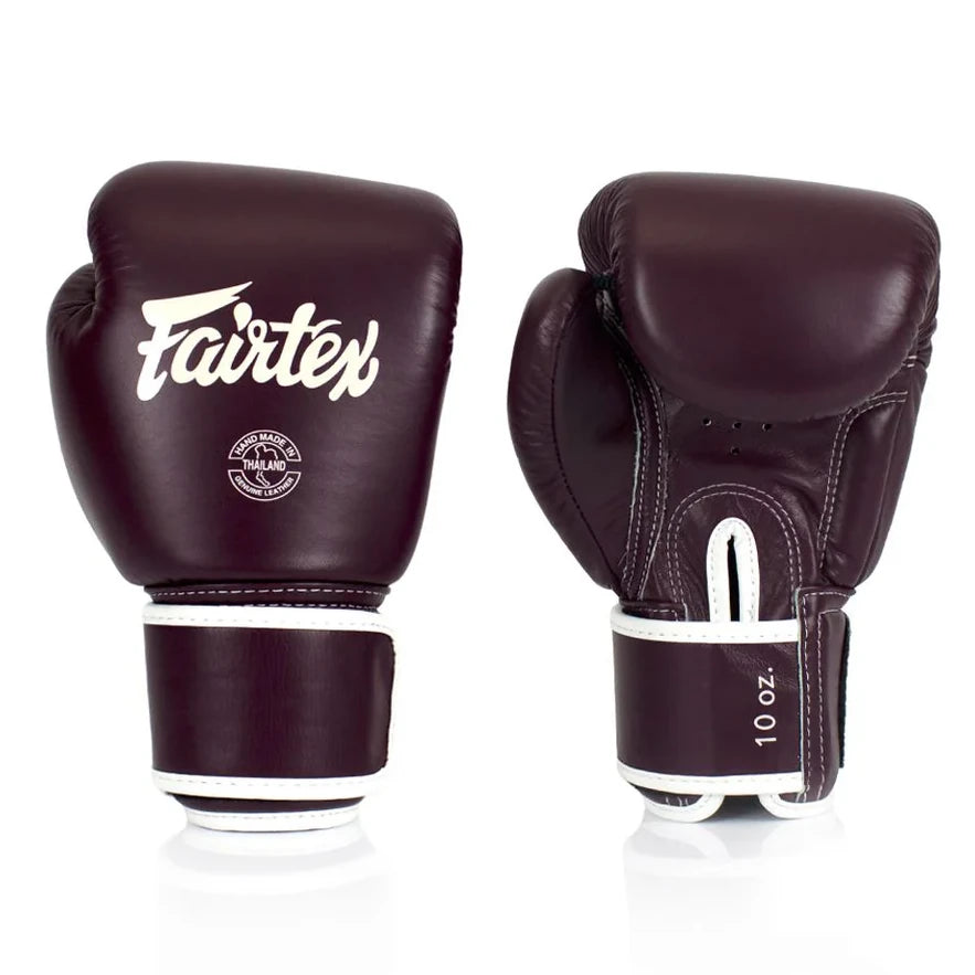 Pair of maroon boxing gloves with white Fairtex logo on a white background