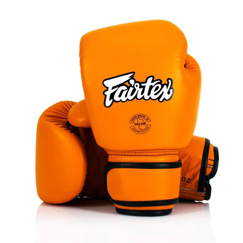 Orange boxing gloves with Fairtex logo on a white background
