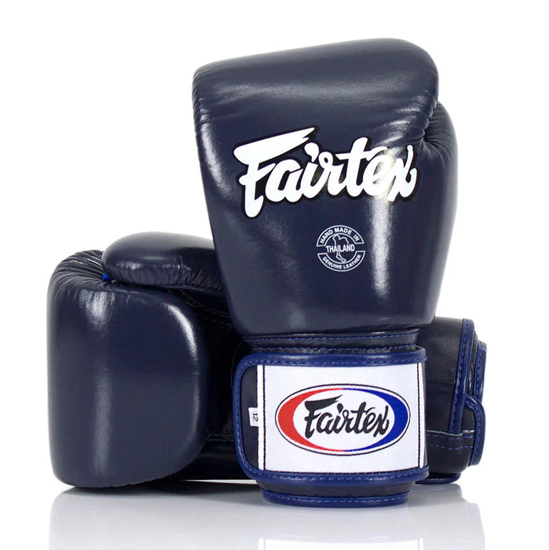 Pair of navy blue boxing gloves with Fairtex logo on a white background