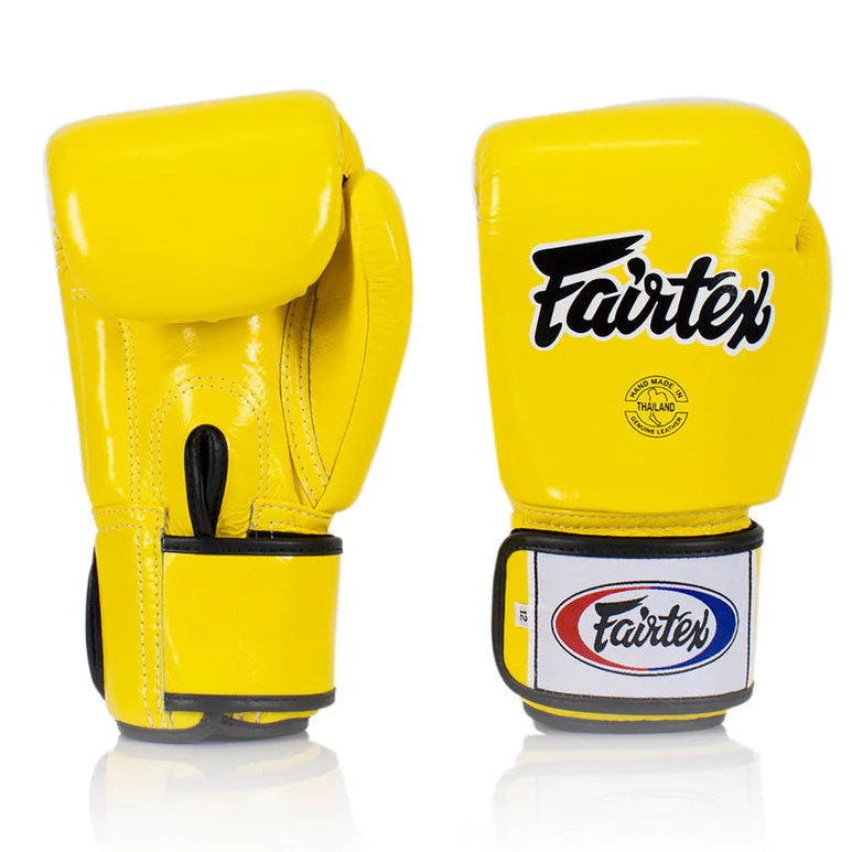 Yellow boxing gloves with Fairtex logo on a white background