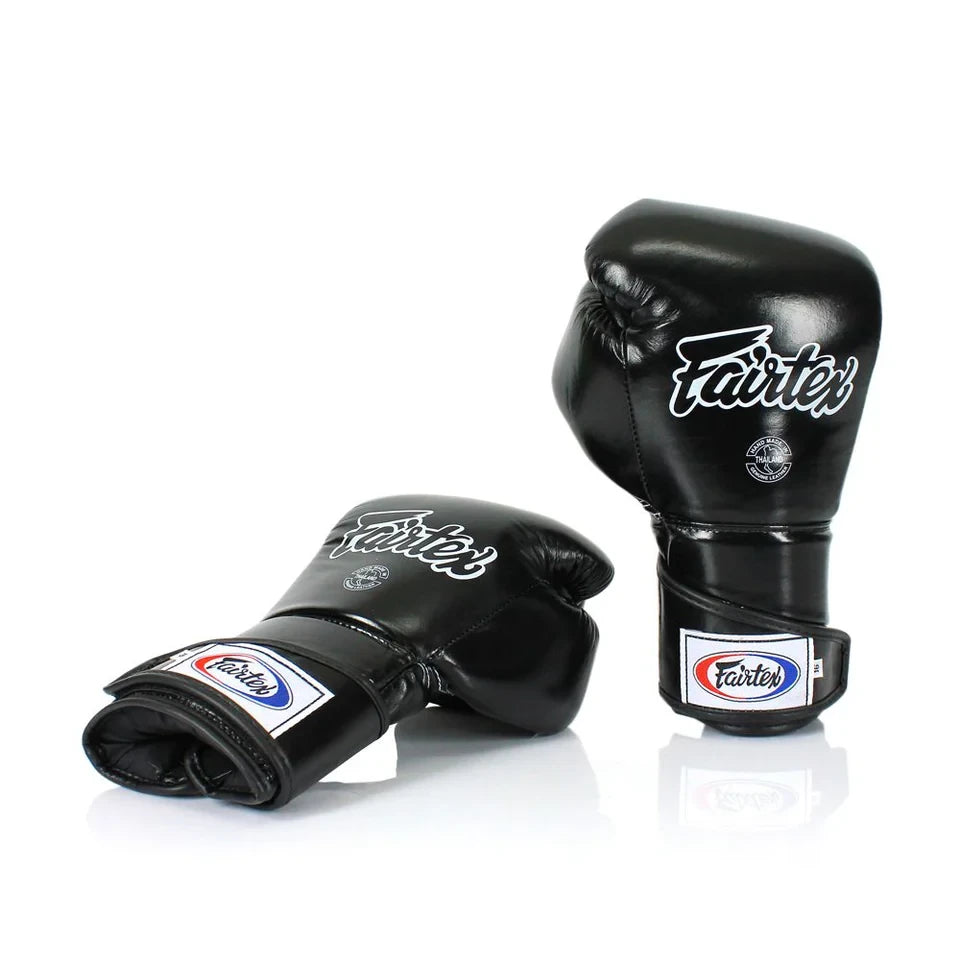 Black boxing gloves with Fairtex branding on a white background