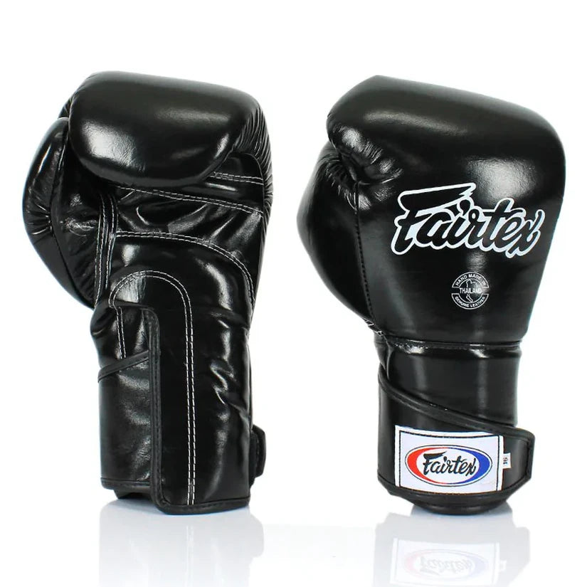 Pair of black boxing gloves with Fairtex logo on a white background