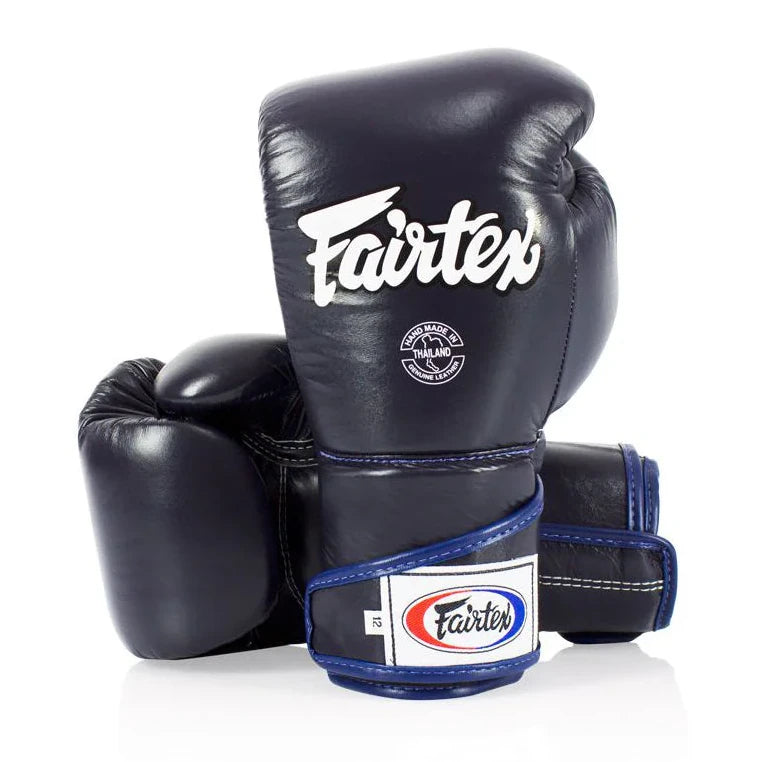 Navy blue boxing gloves with blue accents and Fairtex branding on a white background