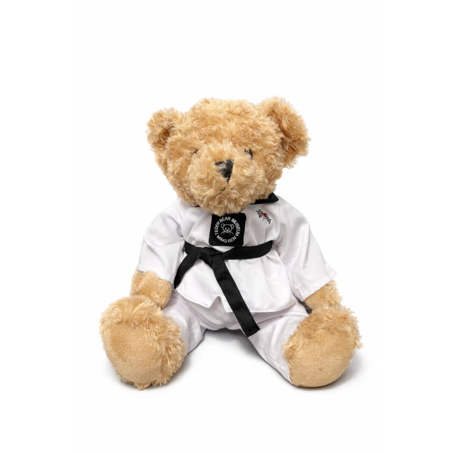 Teddy bear in a white martial arts uniform with a black belt on a white background