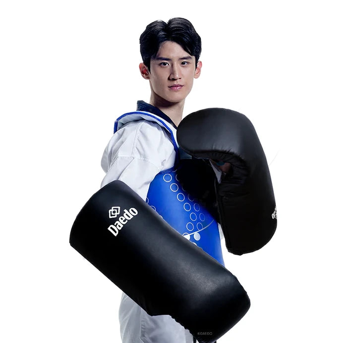 Taekwondo practitioner wearing black arm guards on a white background