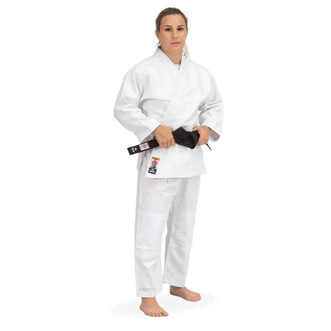 Female wearing a white martial arts uniform with a black belt on a white background