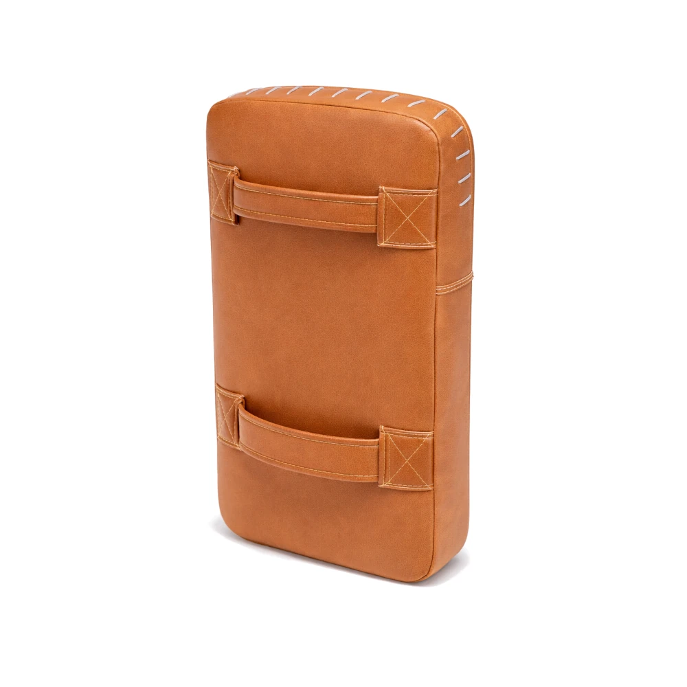 Brown leather kick pad with stitching details on a white background