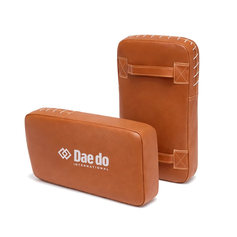 Two brown leather pads with 'Daedo International' logo on a white background