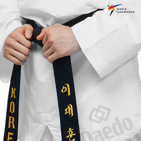 Male wearing a white martial arts uniform with a black belt featuring yellow text, with World Taekwondo logo in the corner.