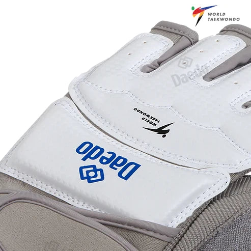Close-up of a white and gray Daedo taekwondo glove with brand logo.