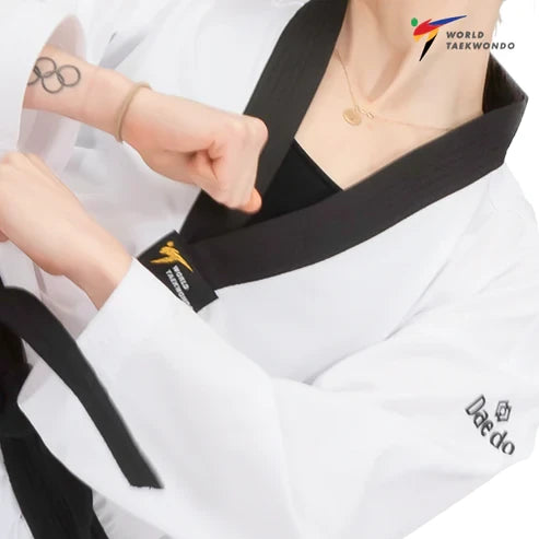 Woman wearing a white martial arts uniform with a black belt, featuring World Taekwondo logo.