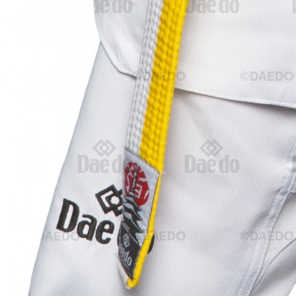 Close-up of a white martial arts uniform with a yellow belt featuring Dae do branding.