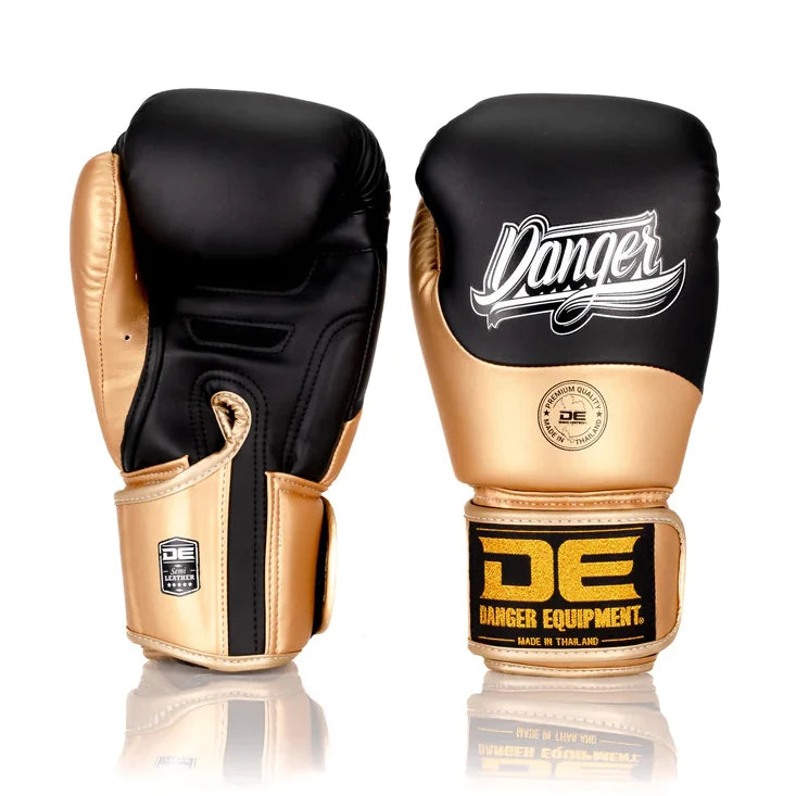 Pair of black and gold boxing gloves with 'Danger Equipment' branding on a white background