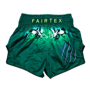 Green Muay Thai shorts with white designs and 'Fairtex' branding on a white background