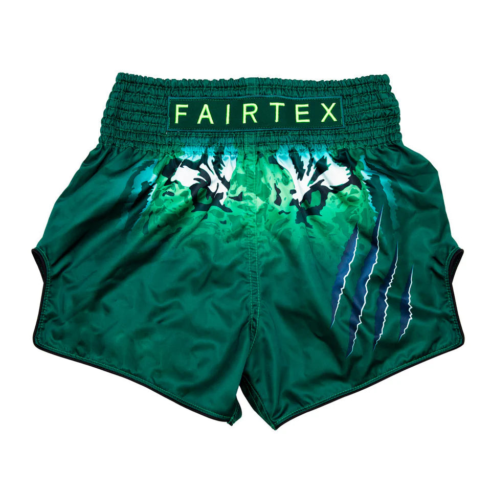 Green Muay Thai shorts with white designs and 'Fairtex' branding on a white background