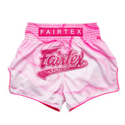 Pink and white Muay Thai shorts with Fairtex logo on a white background