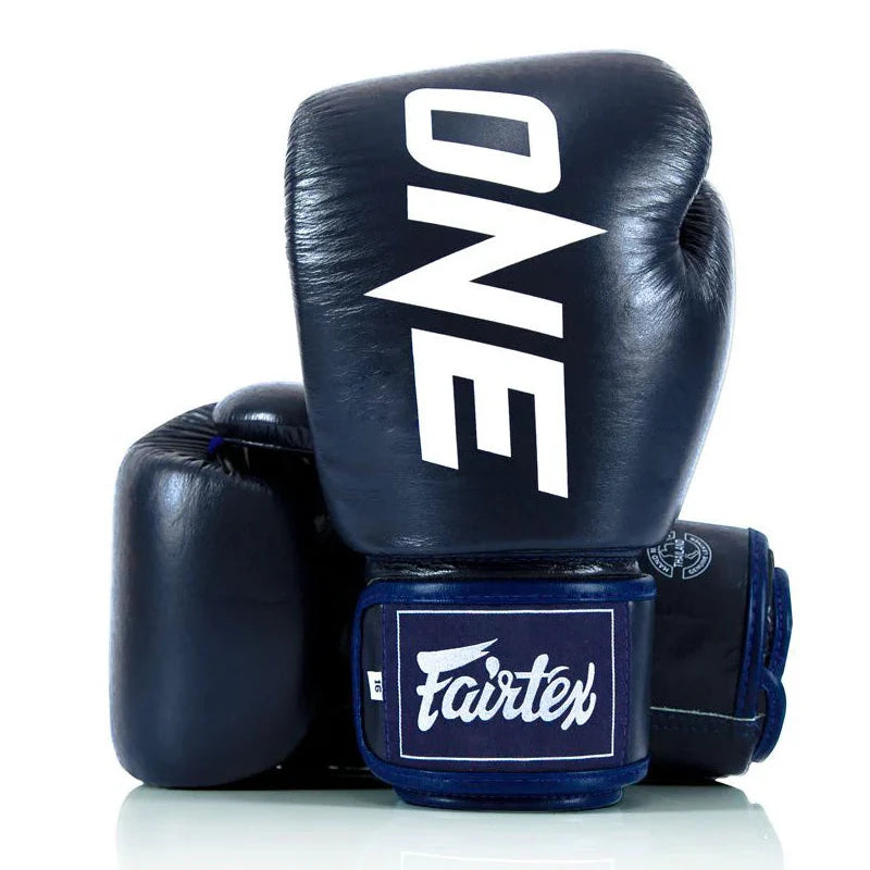 Navy boxing gloves with 'ONE' and 'Fairtex' branding on a white background
