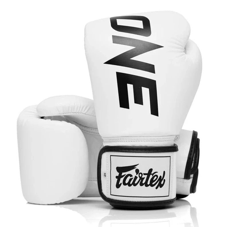 White boxing gloves with 'ONE' and 'Fairtex' branding on a white background