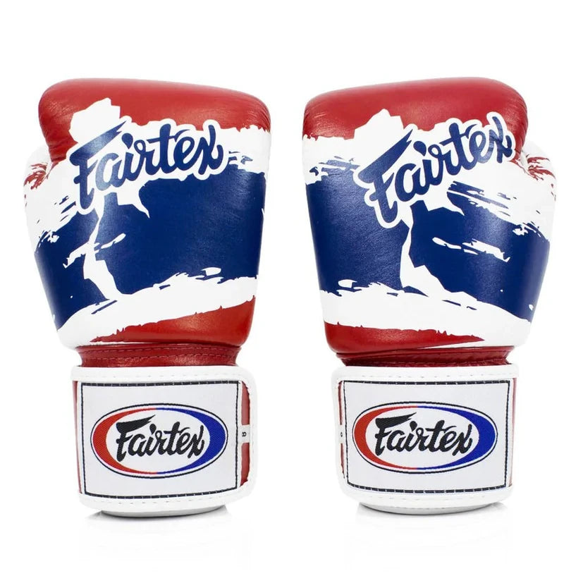 Pair of red, white, and blue Fairtex boxing gloves on a white background