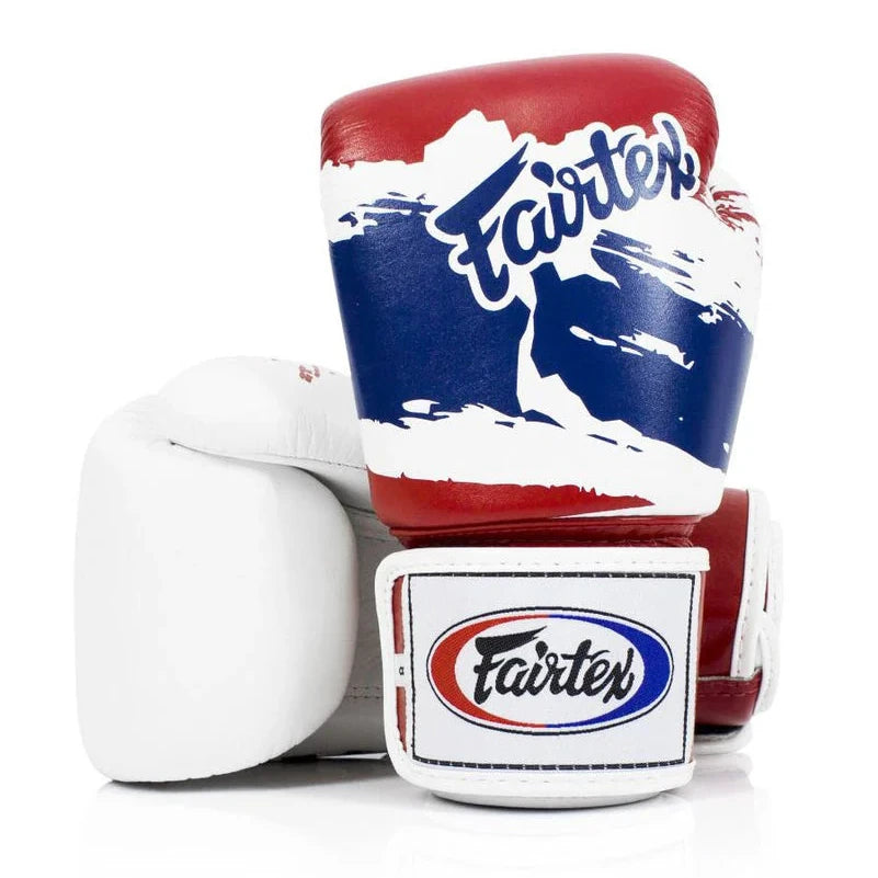 Red, white, and blue boxing gloves with Fairtex branding on a white background