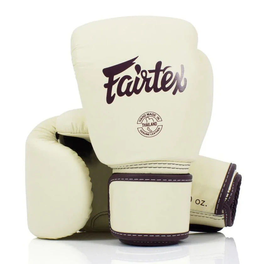 Pair of cream boxing gloves with brown accents featuring the Fairtex logo on a white background.