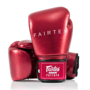 Red Fairtex boxing gloves on a white background
