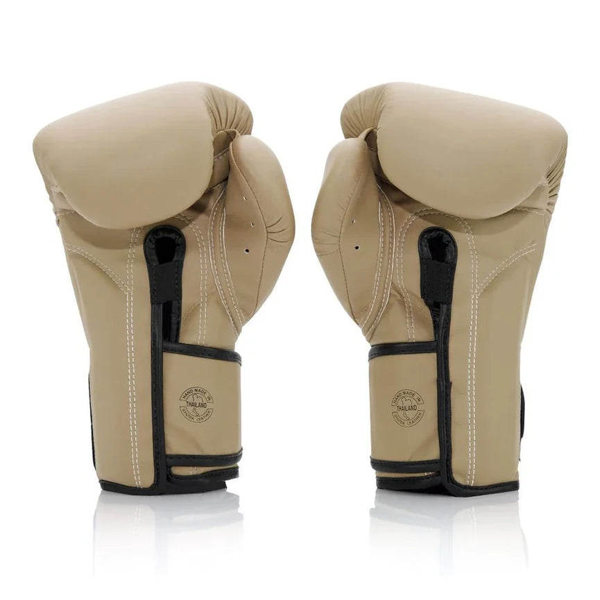 Pair of beige boxing gloves with black accents on a white background