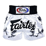 White Muay Thai shorts with black text and Fairtex logo on a white background