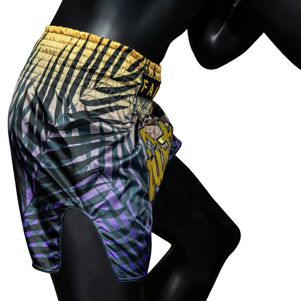 Colorful patterned Muay Thai shorts on a black mannequin against a white background
